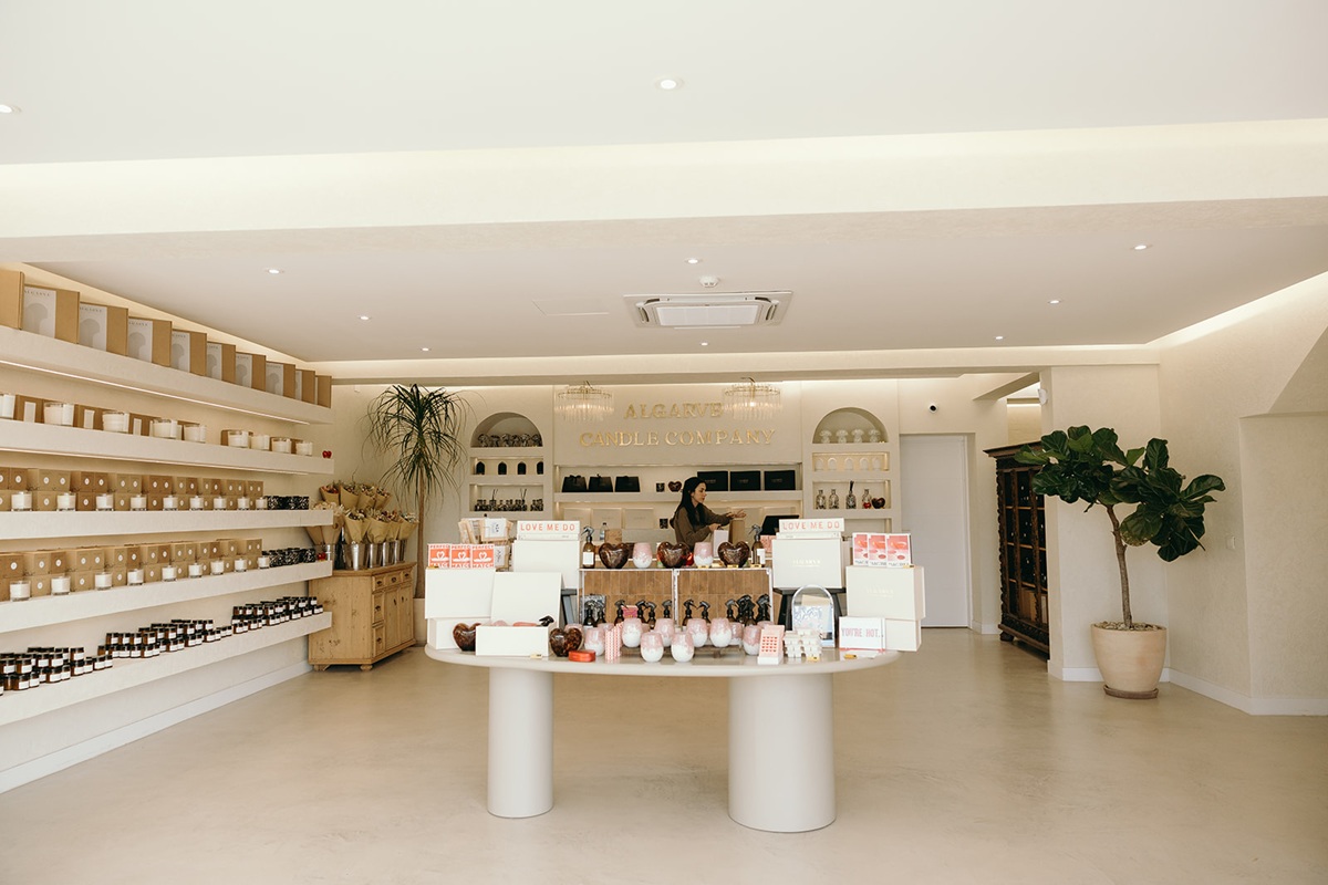 Algarve Candle Company shop interior with central display table, shelves of candles, and gold branding