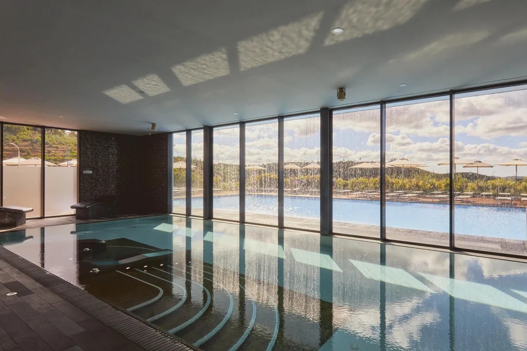 Indoor spa pool looking out to the outdoor pool and Serra hills at Monchique Resort & Spa