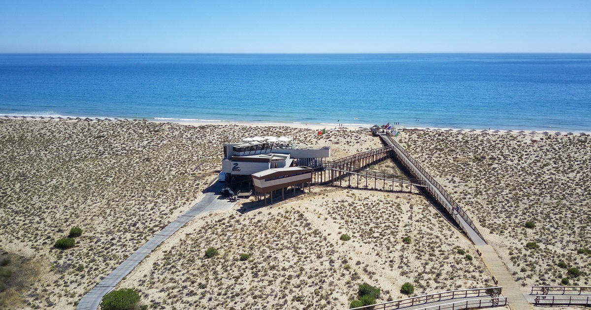 Aerial view of 2 Passos restaurant and boardwalks through the Ancão dunes to the beach
