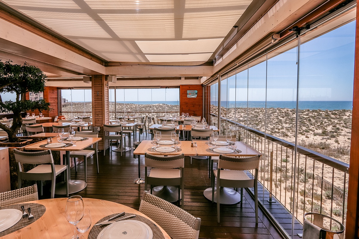 2 Passos dining room with set tables and dune views toward the Atlantic