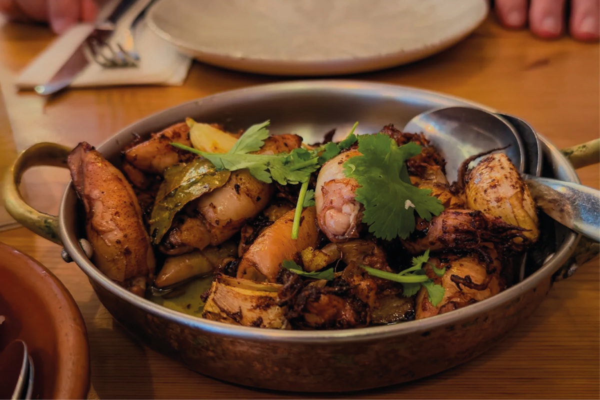 Sautéed squid with garlic, bay leaf and coriander in a copper pan at À do Pinto